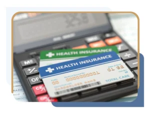 Health insurance cards sitting on a calculator symbolizing out-of-network benefits for breast reduction
